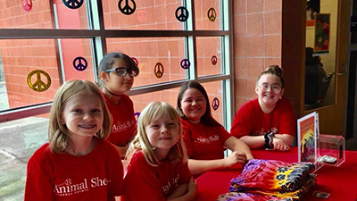 Child volunteers with red volunteer shirts on