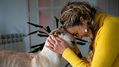 Woman sitting head to head with large white dog